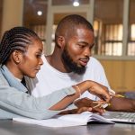 Deux jeunes étudiants travaillent sur leur ordinateur.